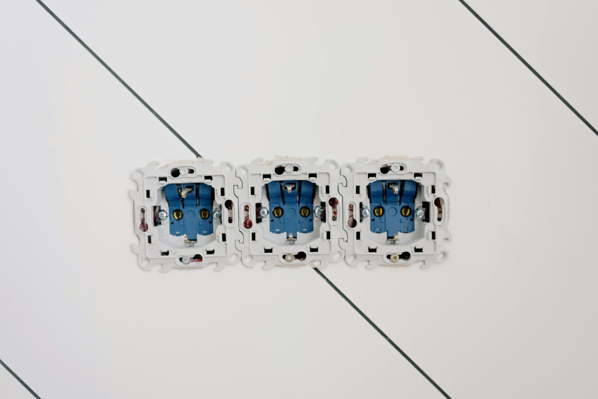 Power sockets with various connectors and bolts on wall in room at home